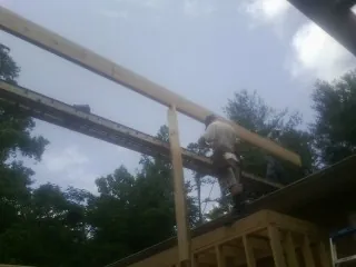 Carpenter setting a ridge beam over a new addition frame — Ice Dam Removal by Roofing Brothers in Carrolltown