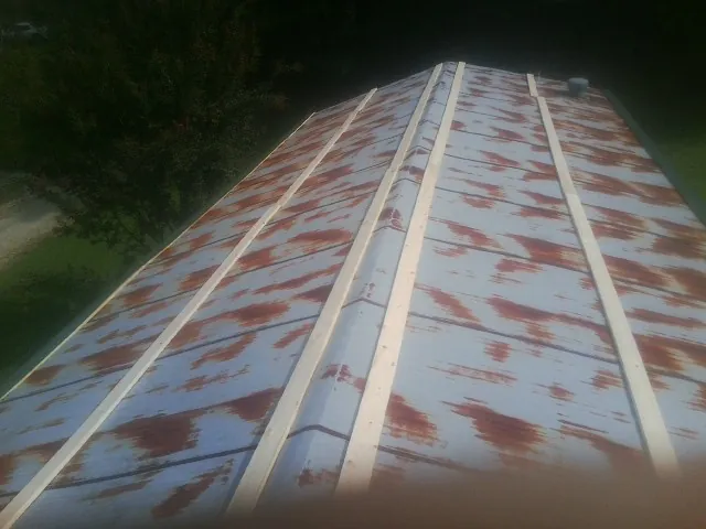 Rusted metal roof panels with new wood purlins before replacement — Storm Damage Roof Repair in Carrolltown by Roofing Brothers