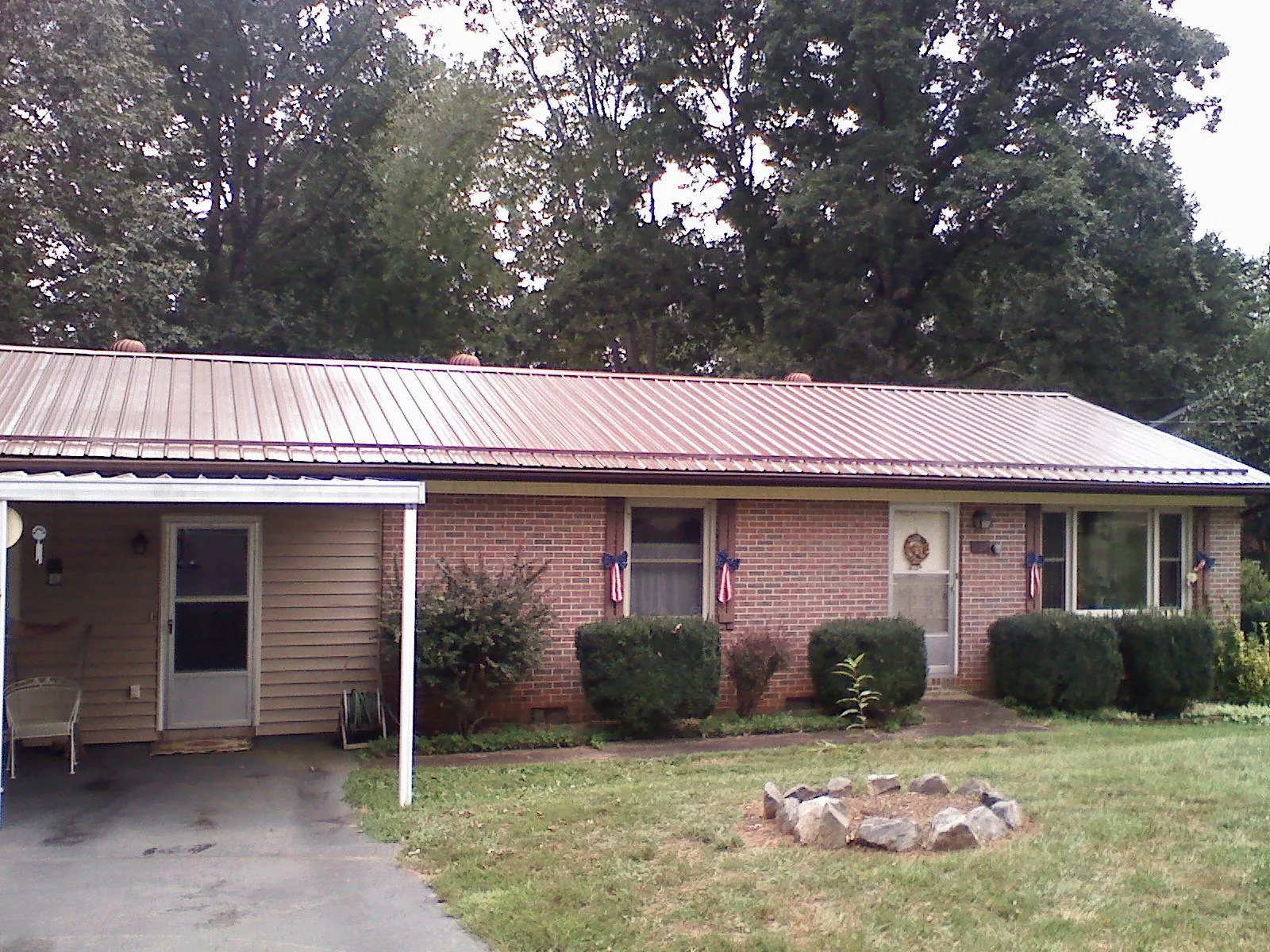 Bronze metal roof and carport on a brick ranch home — Roof Repair work by our crew in Carrolltown